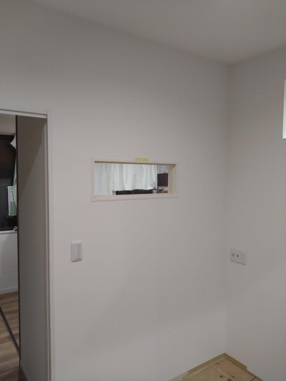 9　事務室クリア開口写真。出隅は触ってもクロスが傷つかないようクロスモールを採用し仕上げとして使用しています。事務室にいながらもご利用者様の状況確認が容易になり、運営する上での利便性のある小開口です。